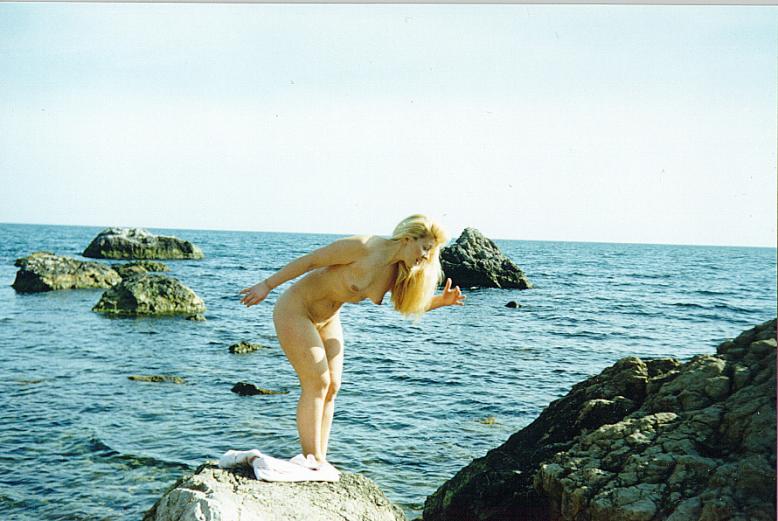 Naked golden goddess on the rocks makes a phenomenal scenic view
