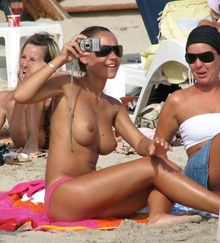 Topless hottie snapping pics at the beach
