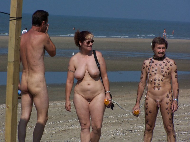 Happy family at the nudist beach man weird tattooed like slave and master