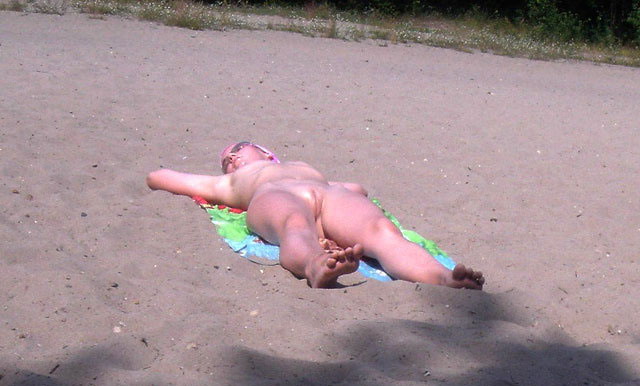 Nude chubby girl caught tanning and exposing her beautiful shaved pussy on the sand