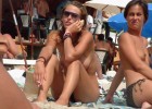 Young naturist babes goes topless on a sunny warm beach