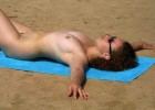 Curly haired nudist lays down like a starfish