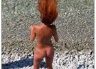 Redhead flips her hair while sunbathing