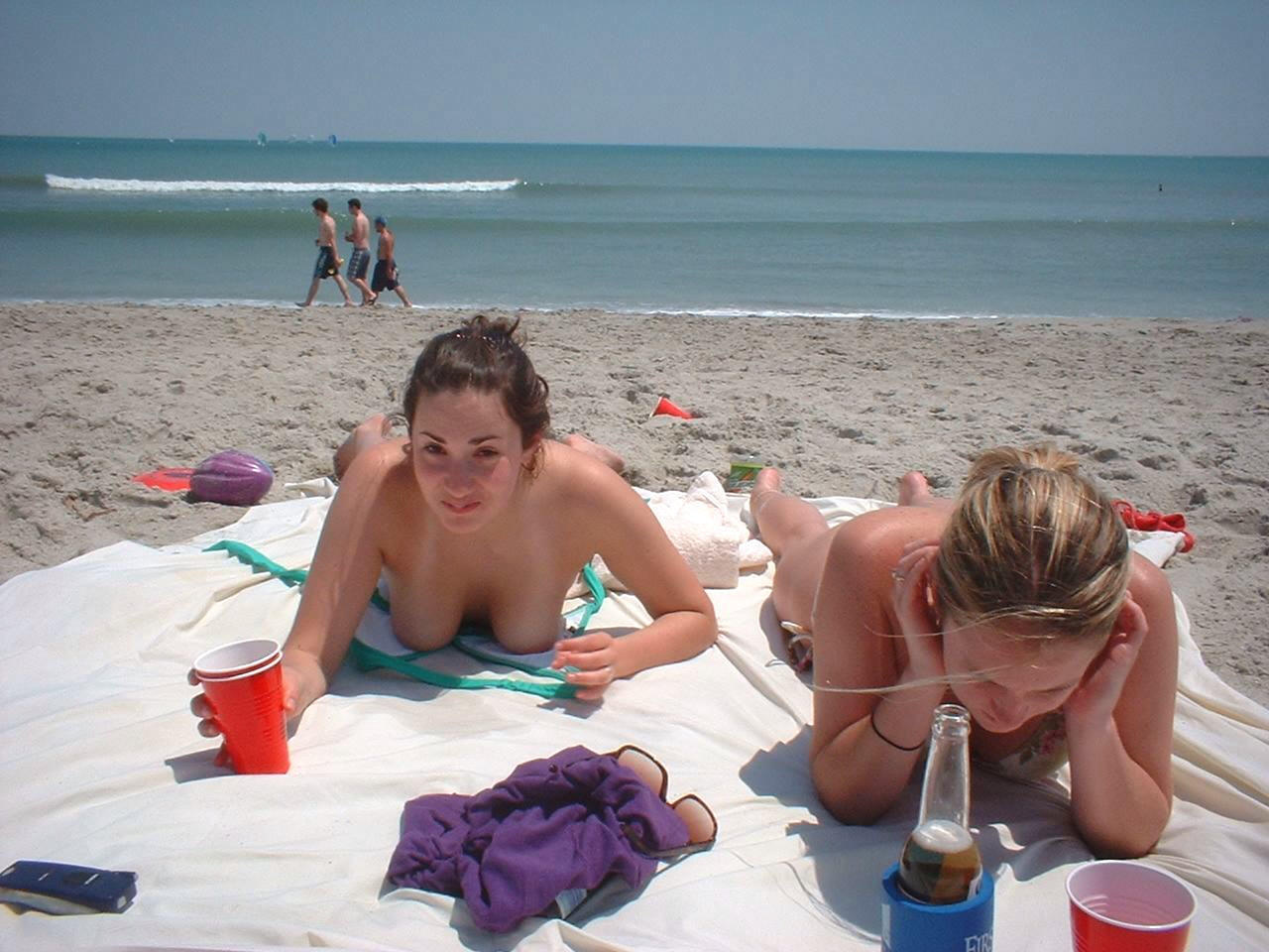 Sunbathing naked chicks enjoying a nice cold bottle of beer