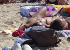 Topless babe canoodling with her boyfriend at the beach