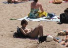 Topless young teen getting her homework done while basking under the blazing sun
