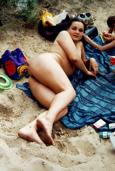 Voluptuous young nudist enjoying a fun picnic at the beach